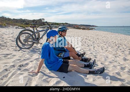 Mountainbiker am Swimcart Beach am Ende des Bay of Fires Trail Stockfoto