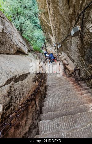 HUA SHAN, CHINA - 4. AUGUST 2018: Die Menschen steigen an den Stufen hinauf, die zu den Gipfeln des Hua Shan Berges, China, führen Stockfoto