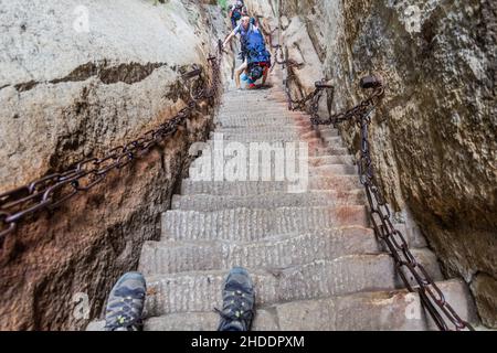 HUA SHAN, CHINA - 4. AUGUST 2018: Die Menschen steigen an den Stufen hinauf, die zu den Gipfeln des Hua Shan Berges, China, führen Stockfoto