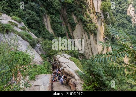 HUA SHAN, CHINA - 4. AUGUST 2018: Die Menschen steigen an den Stufen hinauf, die zu den Gipfeln des Hua Shan Berges, China, führen Stockfoto