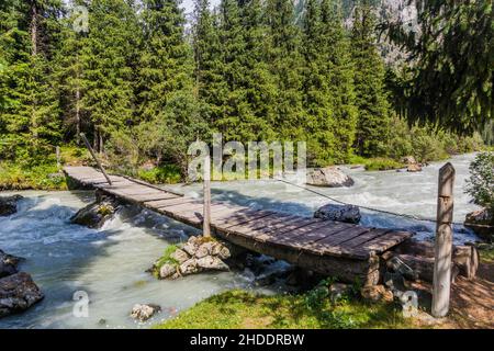 Holzfußbrücke im Karakol-Flusstal in Kirgisistan Stockfoto