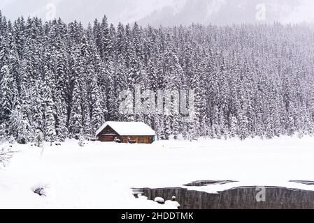 Lake Louise, Kanada - 23 2021. Dez.: Frozon Lake Louise mit Waldblick und Hütte am See Stockfoto