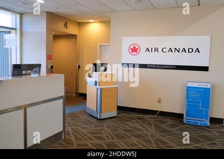 Name und Logo von Air Canada neben einem Check-in-Gate im Savannah-Hilton Head Airport; Savannah, Georgia, USA; leeres Flughafenterminal. Stockfoto