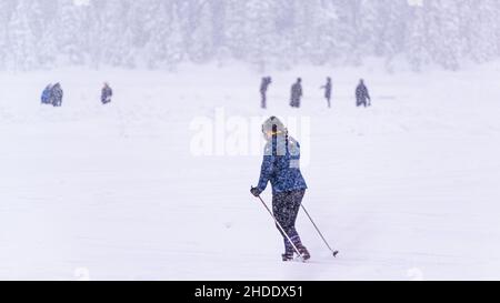 Lake Louise, Kanada - 22 2021. Dez.: Menschen wandern und spielen auf dem gefrorenen Lake Louise in Alberta Stockfoto