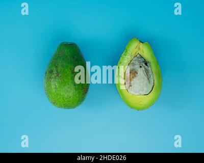 Draufsicht auf Avocado auf blauem Hintergrund. Gesundes Fruchtkonzept. Stockfoto