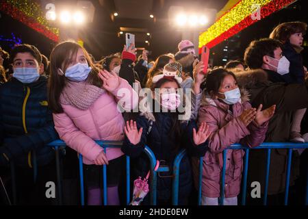 Madrid, Spanien. 05th Januar 2022. Kinder winken während der traditionellen Kavalkade der drei Könige. In diesem Jahr kehrte die Parade mit weniger Öffentlichkeit und restriktiven Maßnahmen aufgrund der Zunahme von Corona-Virusinfektionen auf die Straße zurück (COVID 19). (Foto von Luis Soto/SOPA Images/Sipa USA) Quelle: SIPA USA/Alamy Live News Stockfoto