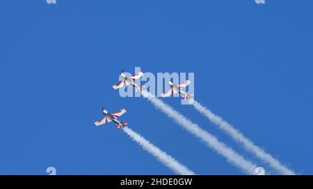 Thiene Italien 16. OKTOBER 2021 Gruppe von Flugzeugen am blauen Himmel mit Rauch und riesigen Kopieflächen. Yakovlev Yak-52 von YAK Italia Stockfoto