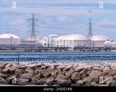 Lagertanks für Erdölprodukte bei Map Ta in der Provinz Rayong in Thailand. Oyster- und Muschelfarmen im Vordergrund. Stockfoto