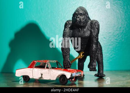 Toy Gorilla hält Schlüssel auf alte rote Auto-Konzept zu arbeiten Stockfoto