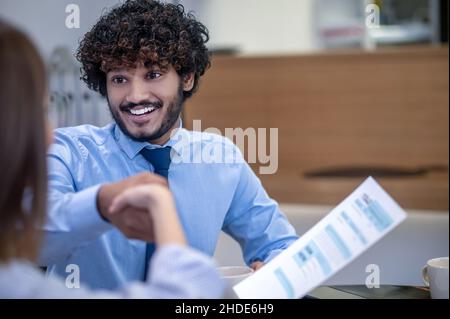 Der junge, lockige indische Mann sieht überrascht aus Stockfoto