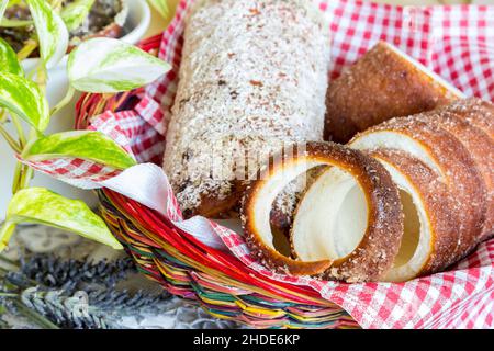 Ungarische traditionelle süße Lebensmittel Kurtoskalacs, auch genannt Schornsteinkuchen im Korb - Makro-Schuss Stockfoto