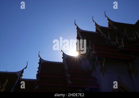 Strahlender Sonnenstrahl, der durch die Giebel-Dächer des Wat Benchamabophit oder des Marmortempels in Bangkok, Thailand, scheint Stockfoto