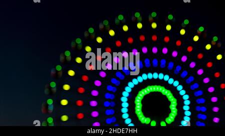 Verschwommene bunte Kreise, Nachtansicht Riesenrad Eindruck. Unscharf für den Einsatz als farbenfroher Hintergrund. Stockfoto