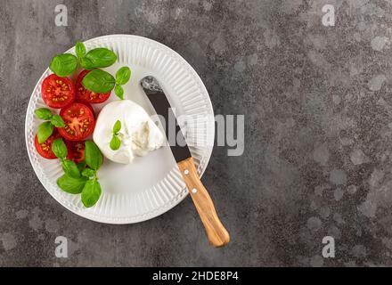 Vegetarische Vorspeise, Tomaten und Burrata-Käse mit Basilikum und Olivenöl. Italienisches Essen. Stockfoto