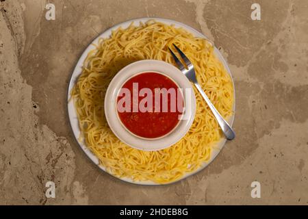 Spaghetti auf dem Teller mit Tomatensauce in der Mitte von oben Stockfoto