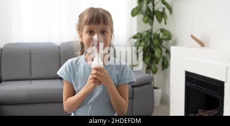 Kleines Mädchen macht Inhalation mit Vernebler zu Hause. Kind Asthma Inhalator Inhalation Vernebler Dampf krank Husten Konzept. Stockfoto