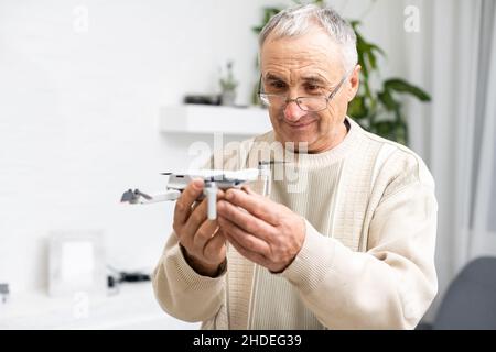 Älterer Mann mit kleinem Modellflugzeug Stockfoto