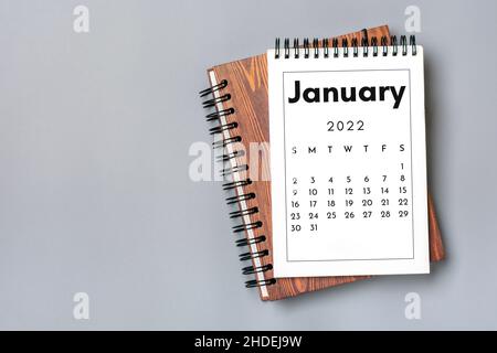 Kalender öffnen Januar 2022 auf grauem Hintergrund Draufsicht Flat Lay Bildung, Ziele, Resolutionen, Plan, Kleineigentümer Geschäftskonzept Home Workplace. Stockfoto