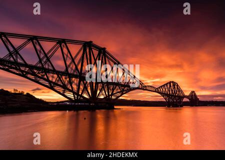 North Queensferry, Großbritannien. 06. Januar 2022 im Bild: Ein atemberaubender Sonnenaufgang über der Forth Bridge. Ein roter Himmel am Morgen soll die Warnung eines Matrosen sein und Schnee und Schneeregen werden in Edinburgh den ganzen Tag über erwartet, um das Sprichwort zu bestätigen. Kredit: Rich Dyson/Alamy Live Nachrichten Stockfoto