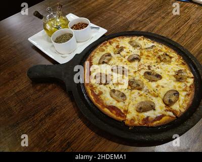 Funghi ist eine Auswahl italienischer Pizza, die traditionell mit Tomatensauce, Mozzarella-Käse, Pilzen, Öl und Petersilie gekrönt wird Stockfoto