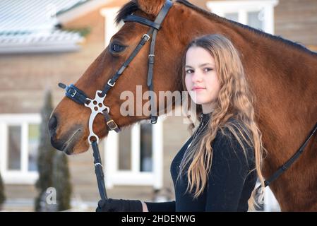 Porträt eines jungen Mädchens mit einem Pferd im Winter. Stockfoto