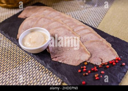 Geschnittene Rinderzungenscheiben auf Holzbrett Stockfoto