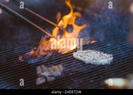 Rindersteak auf dem Grill mit Rauch und Flammen Stockfoto