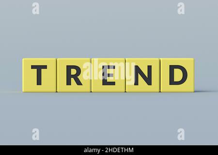 Gelbe Würfel mit Worttrend auf grauem Hintergrund. Neue, wichtige, beliebte Themen in Mode, Musik, Kunst oder Medien. Konzept der neuesten Innovation. Nahaufnahme. 3D Stockfoto