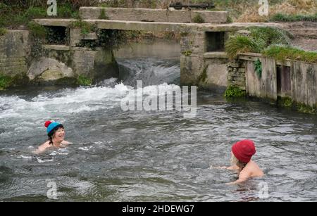 Zwei Personen schwimmen im Fluss Itchen bei Compton Lock in der Nähe von Twyford in Hampshire. Wetterprognosen prognostizieren später am Morgen über den Norden Englands neue Schneefälle. Bilddatum: Donnerstag, 6. Januar 2022. Stockfoto