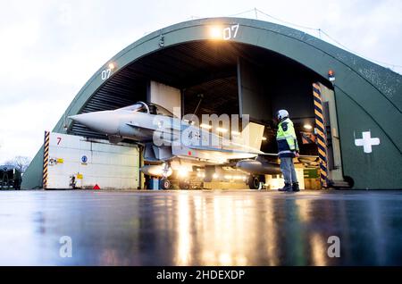 06. Januar 2022, Niedersachsen, Wittmund: Ein Kampfflugzeug der Luftwaffe Eurofighter Typhoon wird aus einem Hangar auf dem Luftwaffenstützpunkt Wittmundhafen vertrieben. Aufgrund einer umfassenden Sanierung des Flugstützpunktes in Wittmund, Ostfriesland, verlegt die Bundeswehr vorübergehend 19 Eurofighter von dort auf den Laage-Stützpunkt südlich von Rostock. Foto: Hauke-Christian Dittrich/dpa Stockfoto