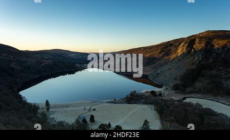 Blick auf den Lough Tay, auch bekannt als Guinness Lake bei Sonnenaufgang an einem knusprigen Wintermorgen. Stockfoto