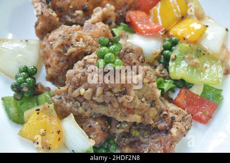 Gebratener Flachfisch mit Zwiebel in schwarzer Pfeffersauce auf dem Teller Stockfoto