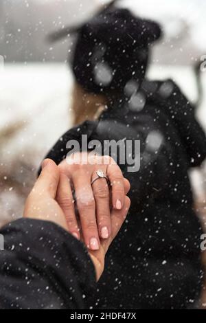 Nahaufnahme der Hand des Mannes, der die Hand des Mädchens mit einem Ring hält. Stockfoto