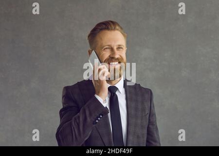 Glücklicher Geschäftsmann mit einem Smartphone und einem Gespräch mit einem Kollegen Stockfoto