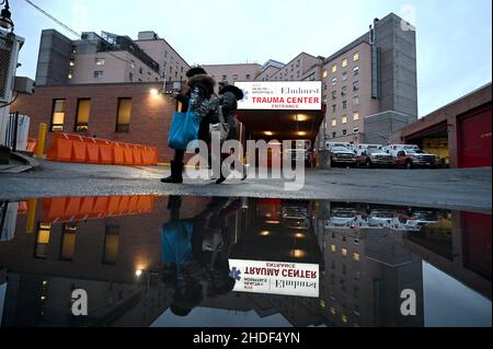 New York, USA. 05th Januar 2022. Zwei Menschen gehen am Eingang des Trauma Center des Elmhurst Krankenhauses vorbei an dem Tag, an dem der Bürgermeister von NYC eine neue Finanzierung für NYC Krankenhäuser im Stadtteil Queens von New York City, NY, am 5. Januar 2022 bekannt gab. Bürgermeister Adams kündigte an, dass die Krankenhäuser der Stadt New York neue Mittel in Höhe von 111M US-Dollar erhalten würden, da die Omicron-Variante von COVID-19 in der ganzen Stadt anstausert und in den Vereinigten Staaten täglich Rekordinfektionen aufstellt. (Foto von Anthony Behar/Sipa USA) Quelle: SIPA USA/Alamy Live News Stockfoto