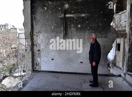 (220106) -- PEKING, 6. Januar 2022 (Xinhua) -- Naim Louis wird am 11. März 2021 in seinem zerstörten Haus in Homs, im Zentrum Syriens, gesehen. (Foto von Ammar Safarjalani/Xinhua) Stockfoto