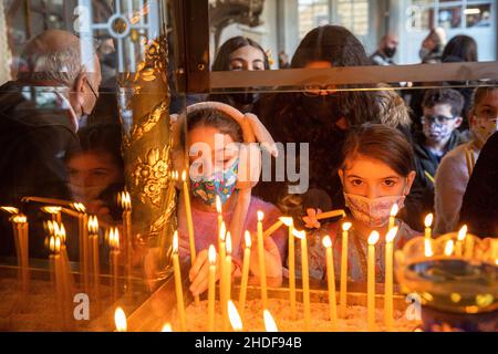 ISTANBUL, TÜRKEI - 06. Januar 2022: Kinder zünden eine Kerze an und beten in der Patriarchalkirche St. George, im Rahmen der Feierlichkeiten zum Epiphanietag Stockfoto