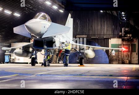 Wittmund, Deutschland. 06th Januar 2022. Ein Luftwaffe Eurofighter Typhoon Kampfflugzeug ist für den Start in einem Hangar auf der Wittmundhafen Air Base vorbereitet. Aufgrund einer umfassenden Sanierung des Flugstützpunktes in Wittmund, Ostfriesland, verlegt die Bundeswehr vorübergehend 19 Eurofighter von dort auf den Laage-Stützpunkt südlich von Rostock. Quelle: Hauke-Christian Dittrich/dpa/Alamy Live News Stockfoto