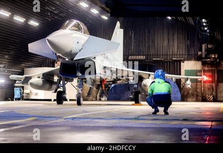 Wittmund, Deutschland. 06th Januar 2022. Ein Luftwaffe Eurofighter Typhoon Kampfflugzeug ist für den Start in einem Hangar auf der Wittmundhafen Air Base vorbereitet. Aufgrund einer umfassenden Sanierung des Flugstützpunktes in Wittmund, Ostfriesland, verlegt die Bundeswehr vorübergehend 19 Eurofighter von dort auf den Laage-Stützpunkt südlich von Rostock. Quelle: Hauke-Christian Dittrich/dpa/Alamy Live News Stockfoto