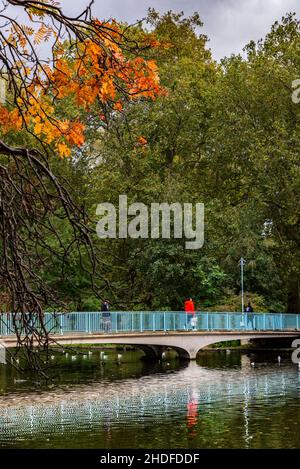 Menschen, die über die Brücke am See im St James Park, London, laufen Stockfoto