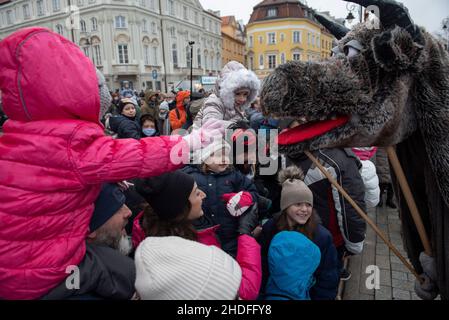 Warschau, Warschau, Polen. 6th Januar 2022. Die Kinder greifen während der Epiphanie-Feier am 6. Januar 2022 in Warschau, Polen, nach einer Puppe, die ein polnisches Folklore-Wesen namens Turon darstellt. Trotz der steigenden Anzahl von SARS-CoV2-Infektionen (Coronavirus) versammelten sich in der Altstadt Hunderte von Menschen, um den Dreikönigstag zu feiern, der in Polen auch als drei-Könige-Tag bekannt ist. (Bild: © Aleksander Kalka/ZUMA Press Wire) Stockfoto