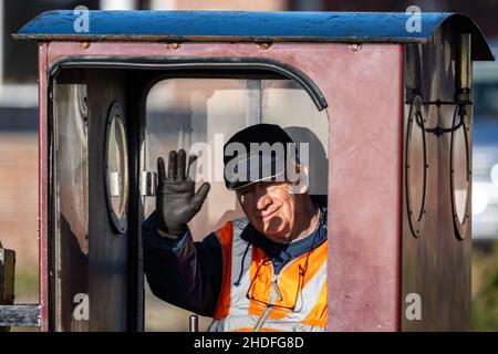 Der Lokführer gibt eine Welle auf der schmalen Hayling Seaside Railway, Hayling Island, Hampshire, Großbritannien Stockfoto