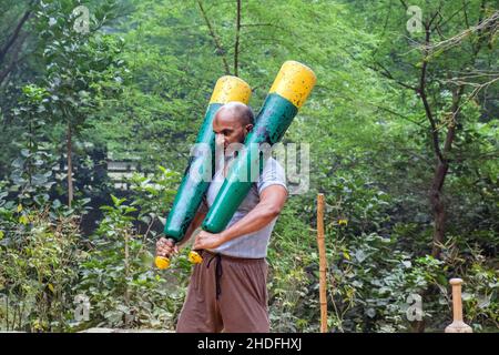 Nicht identifizierte indische Ringer trainieren, indem sie ihre traditionellen Ausrüstungen in der Nähe von ganga Ghat in Varanasi, Uttar Pradesh, Indien, anheben. Stockfoto