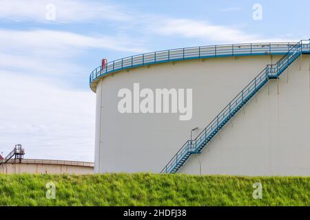 Blaue Leiter, die einen großen Öltank hochfährt Stockfoto