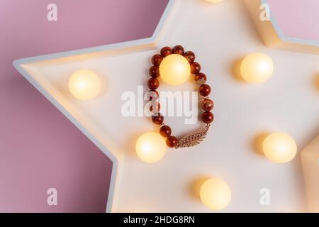 Armband aus Natursteinen auf der Hand aus Naturstein Jaspis. Handgefertigter Schmuck. Selektiver Fokus. Stockfoto