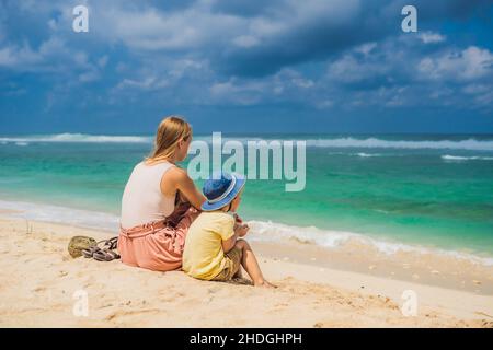 Mutter und Sohn Reisende auf erstaunliche Melasti Strand mit türkisblauen Wasser, Insel Bali Indonesien. Mit Kindern unterwegs Konzept Stockfoto