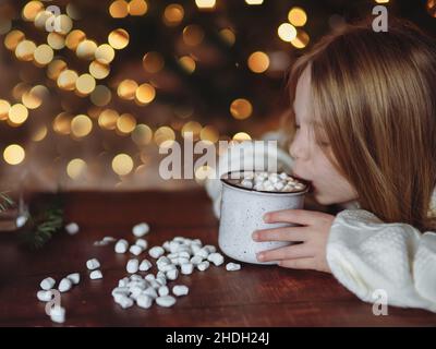 Mädchen trinkt heiße Schokolade mit Marschmalchen während der Weihnachtsferien im Winter Stockfoto
