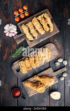 Hausgemachte knusprig gebratene Hühnerteile auf alten dunklen Holztisch, flach legen. Stockfoto