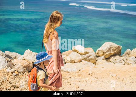 Mutter und Sohn Reisende auf erstaunliche Melasti Strand mit türkisblauen Wasser, Insel Bali Indonesien. Mit Kindern unterwegs Konzept Stockfoto