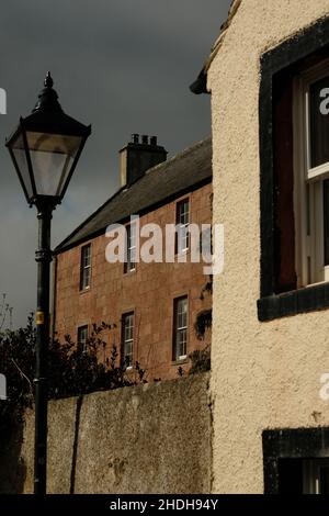 Ein Farbfoto eines ehemaligen Kaufmannshauses im Dorf Cromarty, Schottland. Im Vordergrund ist eine traditionelle Lampenpfosten zu sehen. Stockfoto